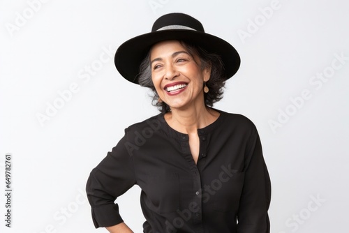 Obraz na płótnie Joyful woman with a happy smile, wearing a hat and white clothing, looking at camera on a white background w salonie