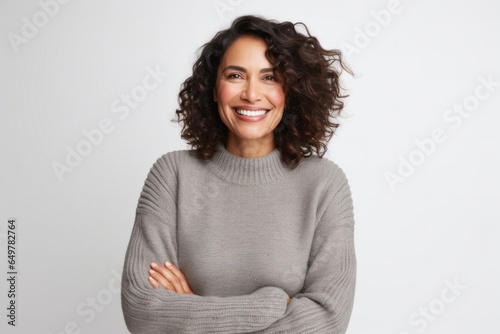 Obraz na płótnie Cheerful woman with curly hair smiling and arms crossed on gray background w salonie