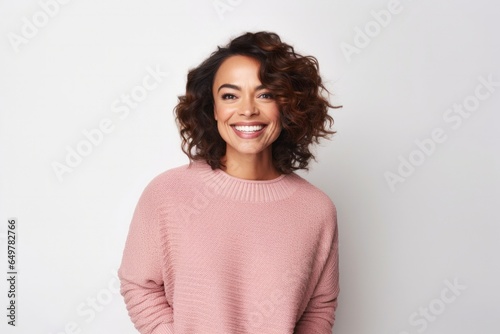 Obraz na płótnie Cheerful woman with curly hair and pink sweater standing on white background w salonie