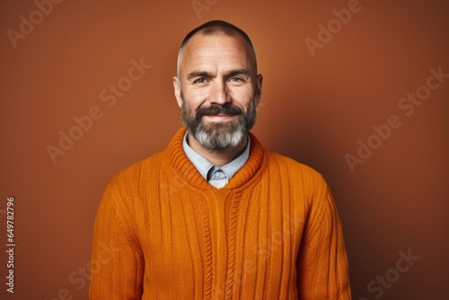 Obraz na płótnie Confident mature man with a beard and casual clothing smiling happily w salonie