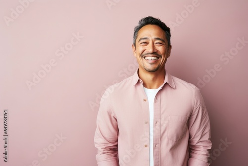Obraz na płótnie Cheerful mature man with beard and casual clothing smiling at camera against colored background w salonie