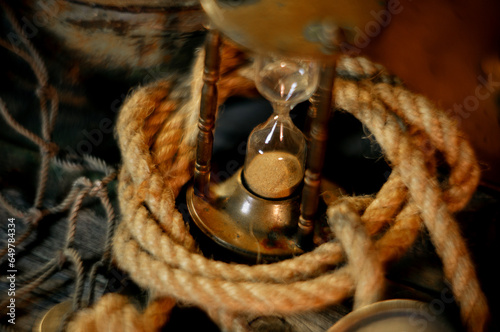 Sea concept on a wooden table background. Closeup vintge hourglass  photo