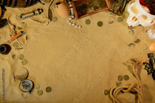 Treasure island theme. Frame on the sand among coins, marine vintage and marine elments. Frame on the sand background photo