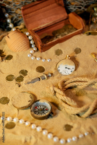 Treasure island theme. Vintge  chest with treasure on the sand among  coins and marine elments on the ocean bottom. photo