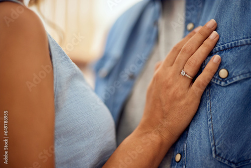 The woman's hand on the man, close up, wearing a wedding ring.