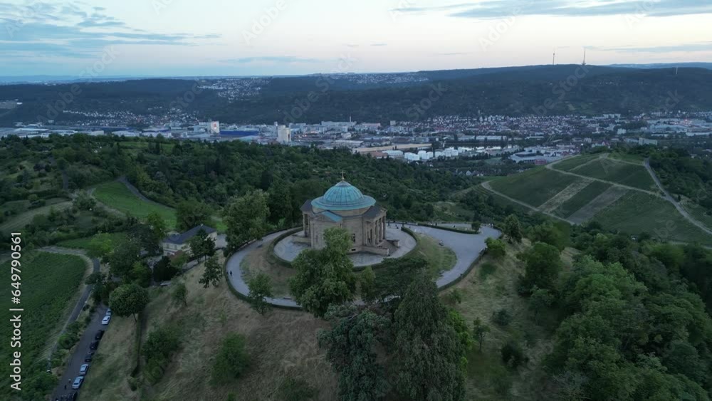 Während die Sonne hinter den Hügeln untergeht, fängt die Drohne die Grabkapelle Stuttgart ein und wirft eine atemberaubende Silhouette gegen den sich verdunkelnden Himmel.