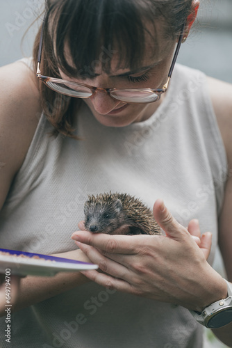 Frau sorgt sich um jungen Igel, Igelbaby, Jungtier. Menschen Tier. Vorsorge. Versorgen. Füttern. Lächelndes Gesicht. Freude.