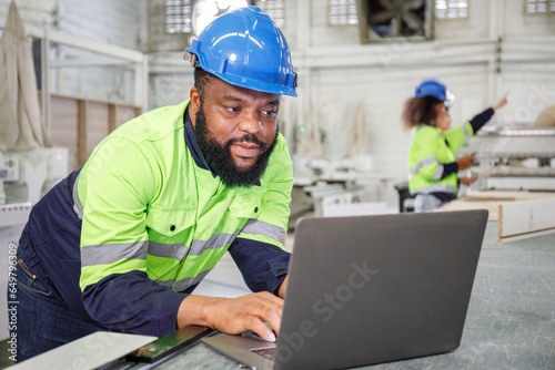 Portrait of a male engineer operating a computer, designing and controlling a machine. in the furniture industry