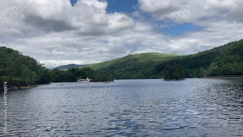 The beautiful calm water of Loch Katrine in the Trossachs National Park with the historic Lady of the Lake ship sailing in the background - Nr Callandar, Scotland, UK photo