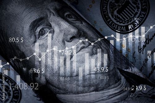 Closeup Benjamin Franklin face on USD banknote with stock market chart graph for currency exchange and global trade forex concept.
