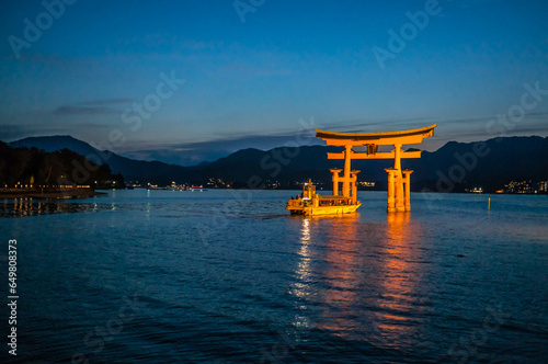 広島 日没後の海に浮かぶ厳島神社の鳥居と小船