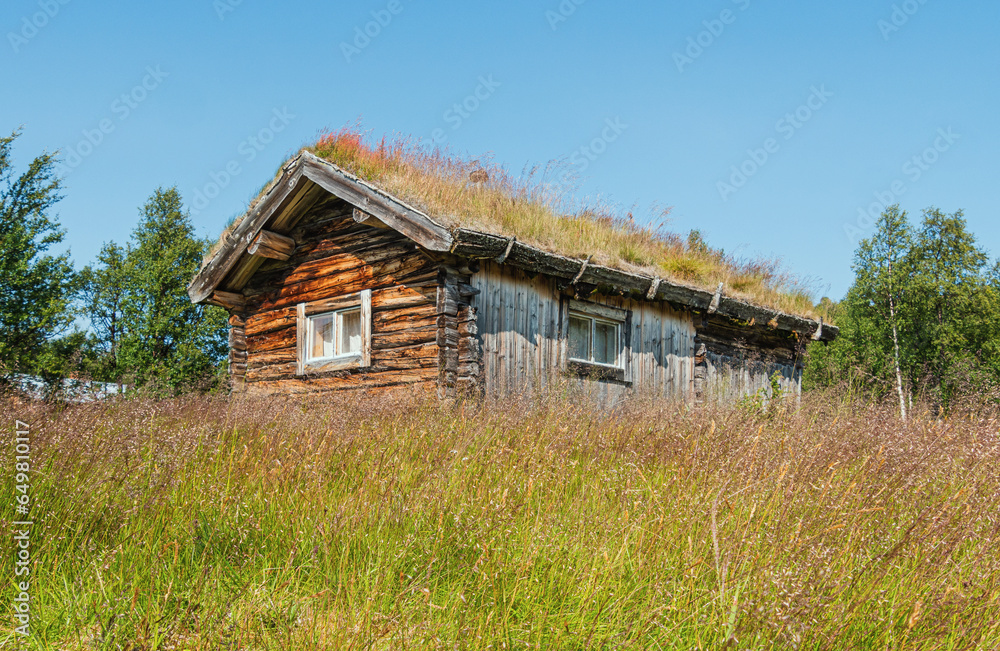 Old wooden house with traditional grass roof in the wilderness of central Sweden Old wooden house with traditional grass roof in the wilderness of central Sweden