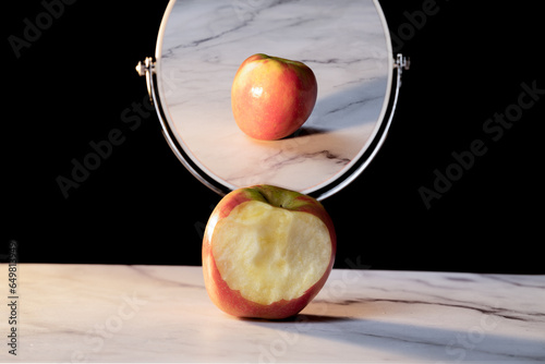 social media fakeness and cheating concept - bitten apple with perfect reflection photo