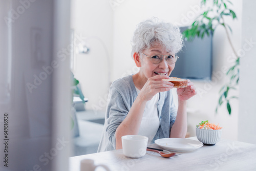 Plakat w ramie 笑顔で朝食を食べるシニアの女性