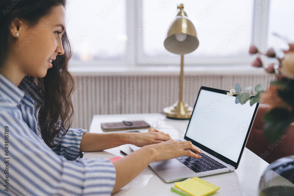 Young woman using laptop at table at home Young woman using laptop at table at home