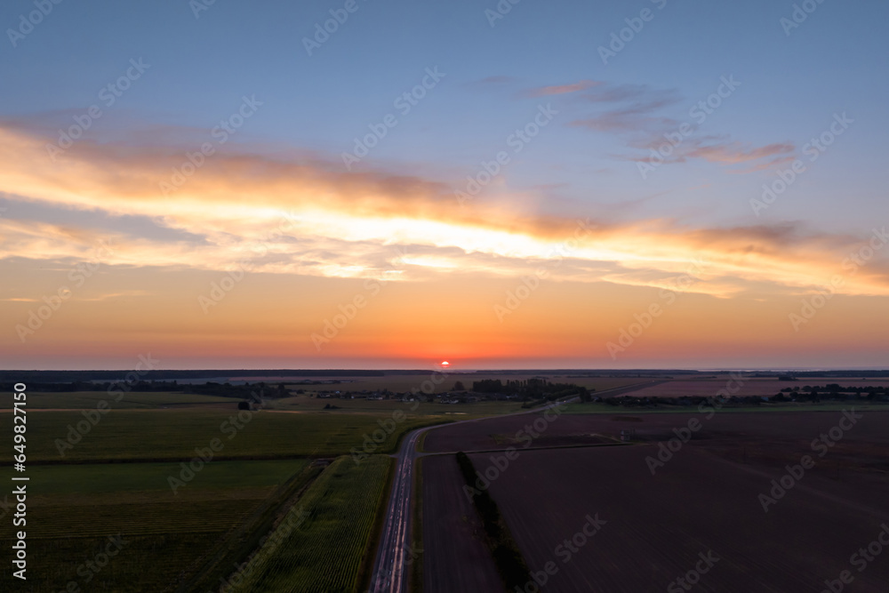 Fototapeta premium Blue violet red sunset sky background with evening curly rolling clouds may use for sky replacement