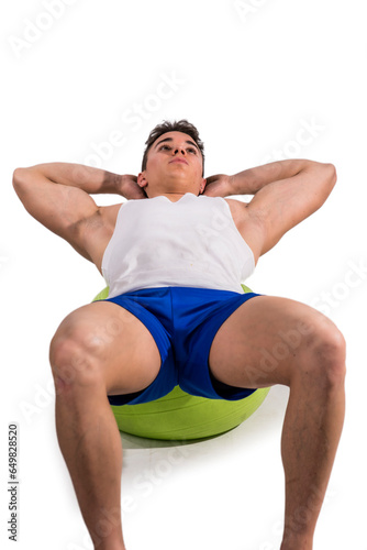 A man sitting on top of a green ball. Photo of a man sitting on top of a green exercise ball in a studio shot isolated