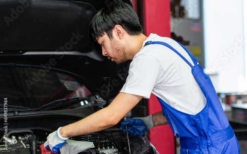 Portrait Adult Professional handsome male mechanic wearing uniform, fix, repair, check, inspect car engine, standing in automobile maintenance service center or shop.