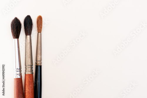 Three watercolor brushes on the left on white background.Creativity concept. Art.