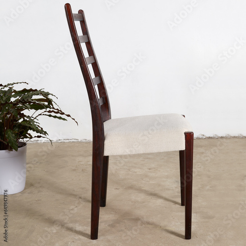 Elegant Mid-Century Modern rosewood dining chair. Vintage dark wood ladderback chair. Interior photograph. Side view.  photo