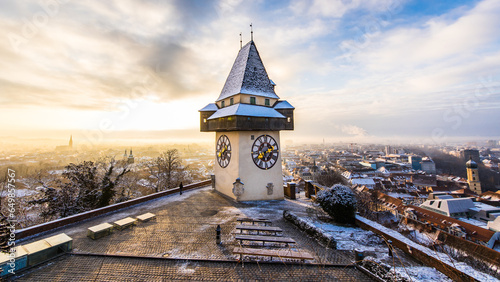 Winter in Graz, with the Uhrturm and Schloßberg covered with snow during sunrise