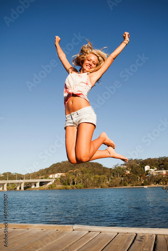 A Young Woman Jumps In The Air; Currumbin, Gold Coast, Queensland, Australia
