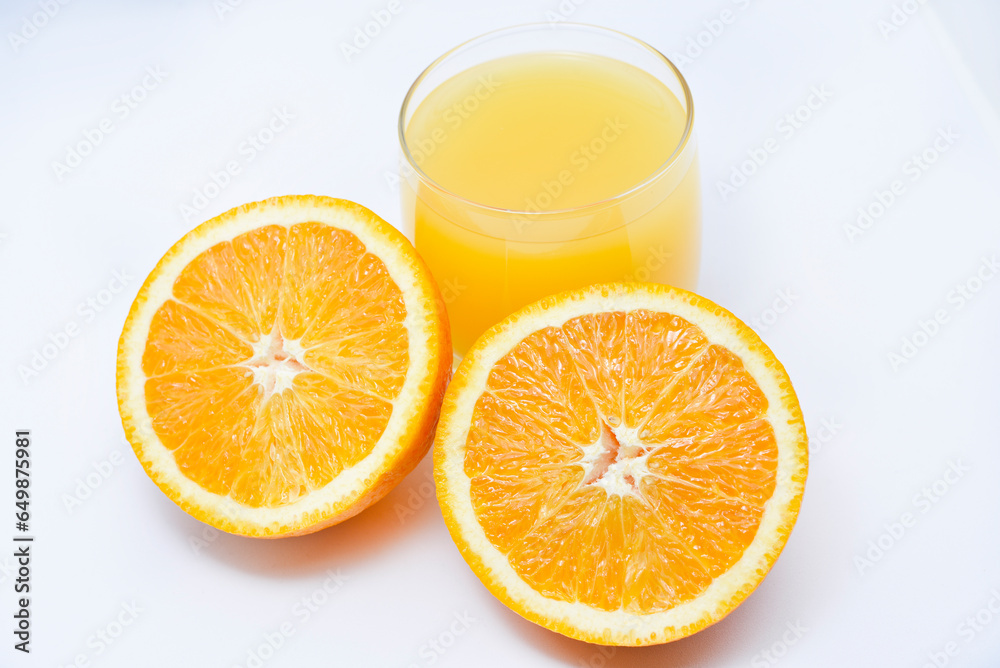 Orange juice in a glass glass and the fruit of oranges. Refreshing drink on a white background of fruit. Orange juice in a glass glass and the fruit of oranges. Refreshing drink on a white background of fruit.