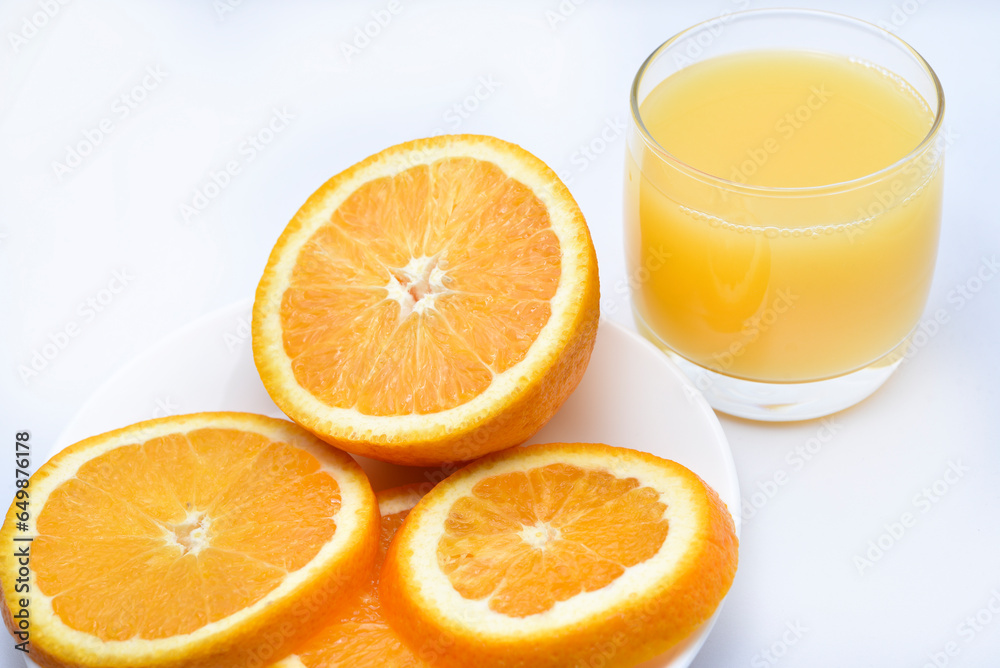 Orange juice in a glass glass and the fruit of oranges. Refreshing drink on a white background of fruit. Orange juice in a glass glass and the fruit of oranges. Refreshing drink on a white background of fruit.