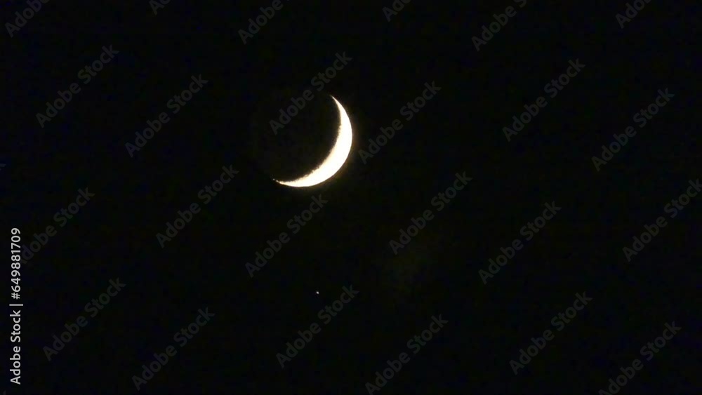 Dark night sky crescent moon during conjunction of moon and planet Jupiter - natural view before moonset in timelapse. Topics: astronomy, atmosphere, cosmos, science, nature, weather Dark night sky crescent moon during conjunction of moon and planet Jupiter - natural view before moonset in timelapse. Topics: astronomy, atmosphere, cosmos, science, nature, weather