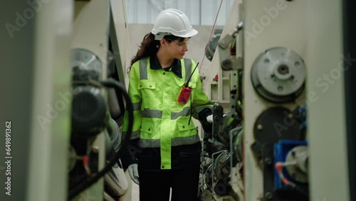 Maintenance engineer inspects machinery in a cardboard parts factory.
