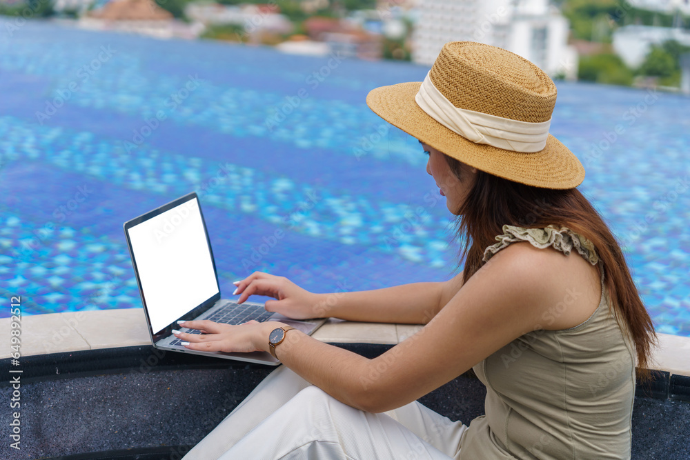 Asian woman digital nomad freelancer work typing laptop on online meeting Remote work happy working digital nomad in sunny blue water pool.