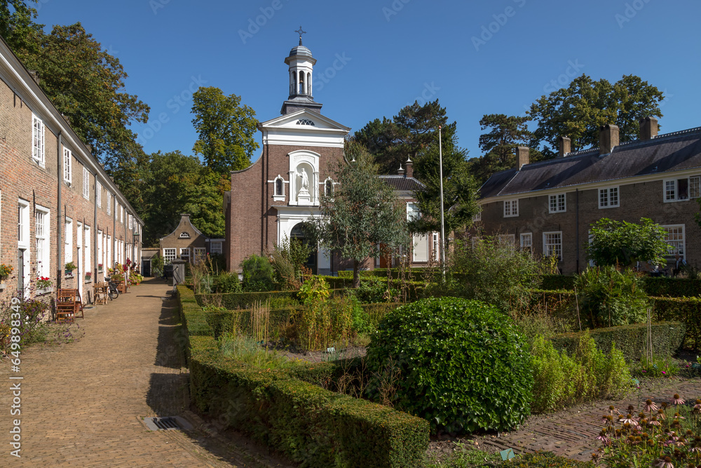Beguinage in Breda with 29 houses around a herb garden with the Saint Catherine Church in the background.