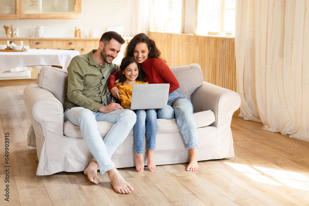 Parents and daughter girl using laptop computer together at home Parents and daughter girl using laptop computer together at home