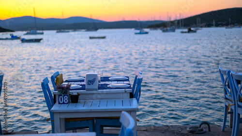 romantic Dinner table, Sunset Orange sky and sailboat waiting in the calm sea, Sunset view in Fethiye bays, Calmness and meditation photo