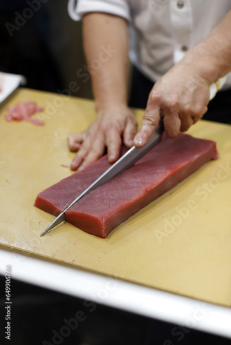 chef cutting red tuna loin for sushi making