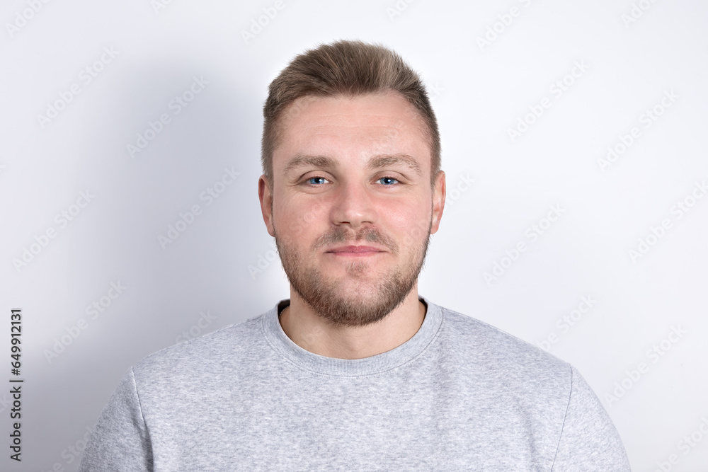 Portrait of a real nice smiling young blond man with blue eyes and stubble on his face on a plain light background, feelings and positive emotions, looking directly into the camera,copyspace, close-up Portrait of a real nice smiling young blond man with blue eyes and stubble on his face on a plain light background, feelings and positive emotions, looking directly into the camera,copyspace, close-up