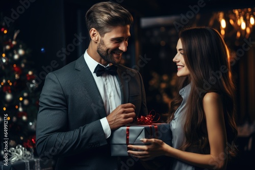 smiling man in a business suit gives a gift to a woman