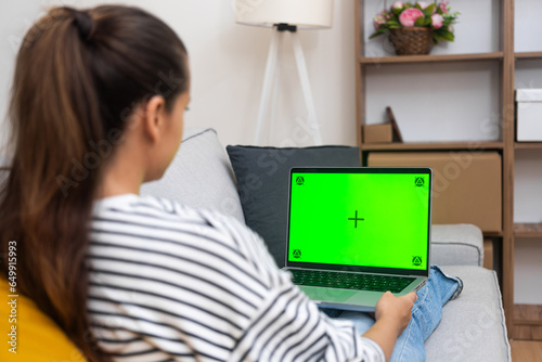 Ταπετσαρία Brunette woman with long ponytail rests looking at laptop screen with chromakey