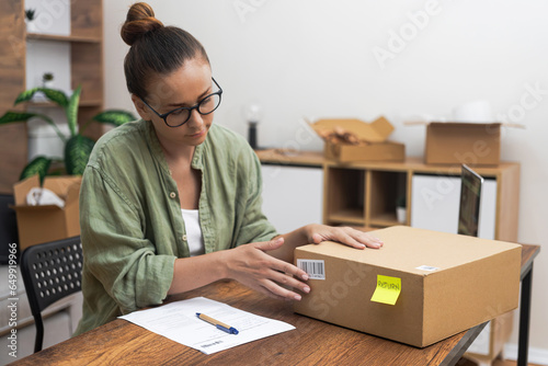 young woman's commitment as she sits at her table, using her laptop and writing a return order, expressing her desire to return a product. 