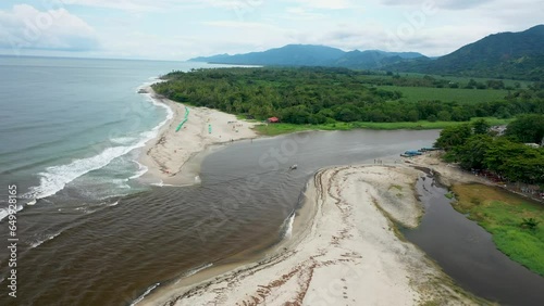 Breathtaking Drone Footage: Tranquil River Meeting Azure Sea – A Solitary Boat Navigating Close to the Picturesque River Mouth