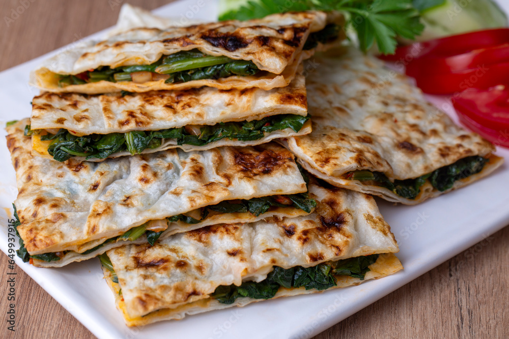 Traditional Turkish food, Turkish pancake gozleme with cheese and herb. The appetizer is Turkish pastry. There are varieties such as cheese, spinach, potato. - obrazy, fototapety, plakaty 