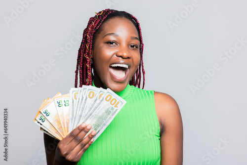 Happy smiley baker African American dark skinned baker woman with colourful braids smiling standing in the studio wearing casual outfit holding selfmade delicioua tasty cake in hands shop adverb photo