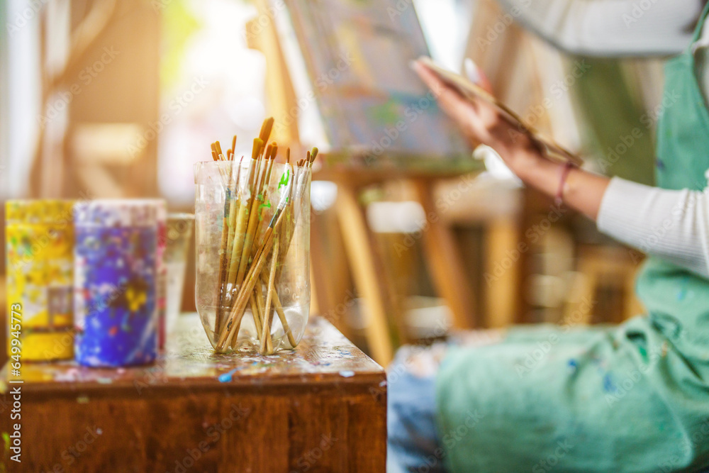 Young woman artist painting on canvas at art studio. Young woman artist painting on canvas at art studio.