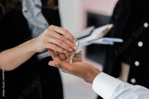 Confident real estate blonde agent handed over the keys to the satisfied African-American man, assuring him that he made the right decision in choosing her