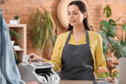 Female cashier using cash c...