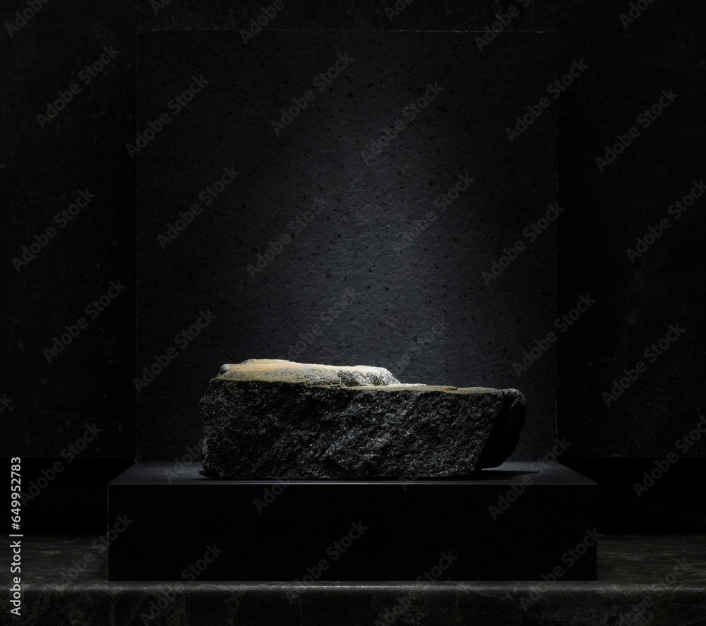 stones for the podium on a dark gray background. black, gray natural stones with texture for product presentation, background, podium.