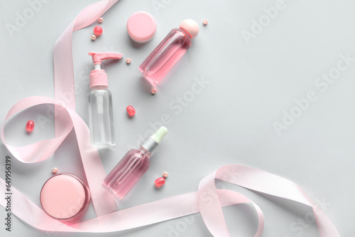 Composition with cosmetics, beads and satin ribbon on blue background