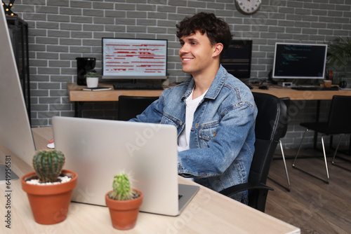 Smiling young man working o...