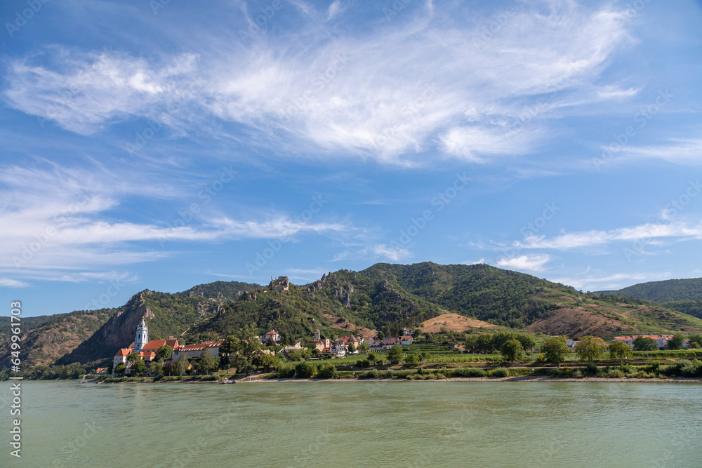 Cruising By a Village Along the Danube River, Austria in Summertime, with views of Vineyards, Church, Homes and Durnstein Abbey Cruising By a Village Along the Danube River, Austria in Summertime, with views of Vineyards, Church, Homes and Durnstein Abbey