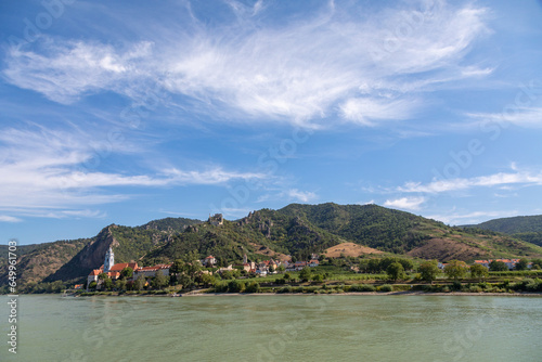 Cruising By a Village Along the Danube River, Austria in Summertime, with views of Vineyards, Church, Homes and Durnstein Abbey